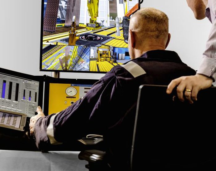 Two individuals in a control room, where one operates multiple monitors displaying various data and a construction scene.