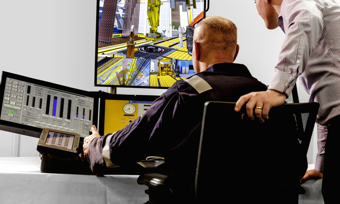 Two individuals observe and interact with data and simulations on multiple monitors in a control room setting. The scene includes industrial equipment displayed on the screens.